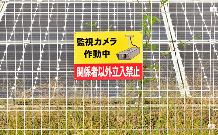 太陽光発電施設のフェンスと警告ポスター