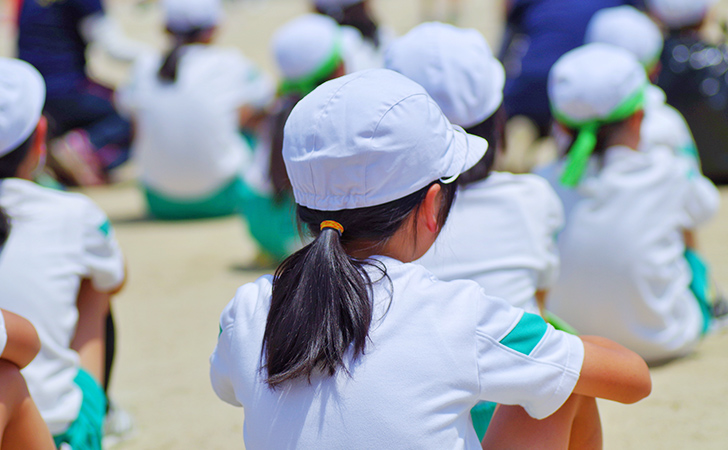 体育座りをする小学生